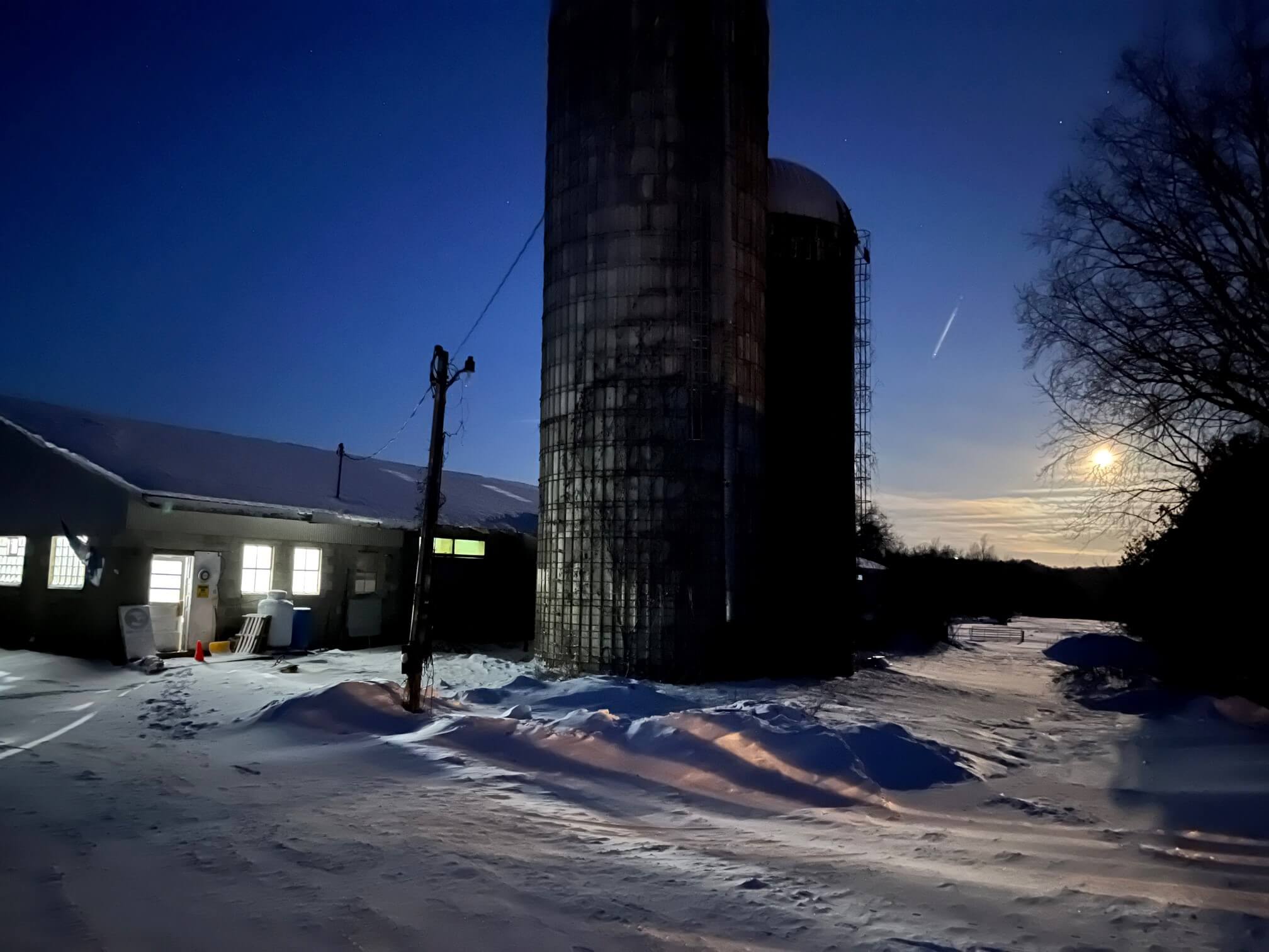 barn and silos in snow at dusk