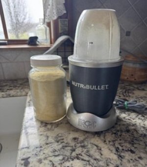 garlic powder in glass jar by grinder